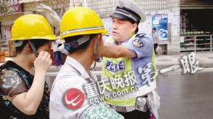 乘客未戴安全帽,彭水交巡警大队长王小兵给她戴上。